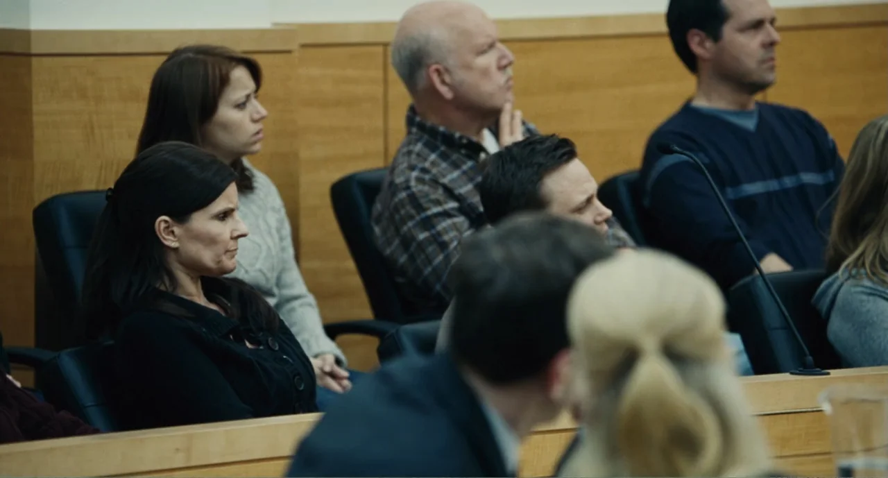 Bad Boys: A True Story (2003) movie still: medium — A courtroom gallery features rows of black padded chairs against light wood paneling. A group of…