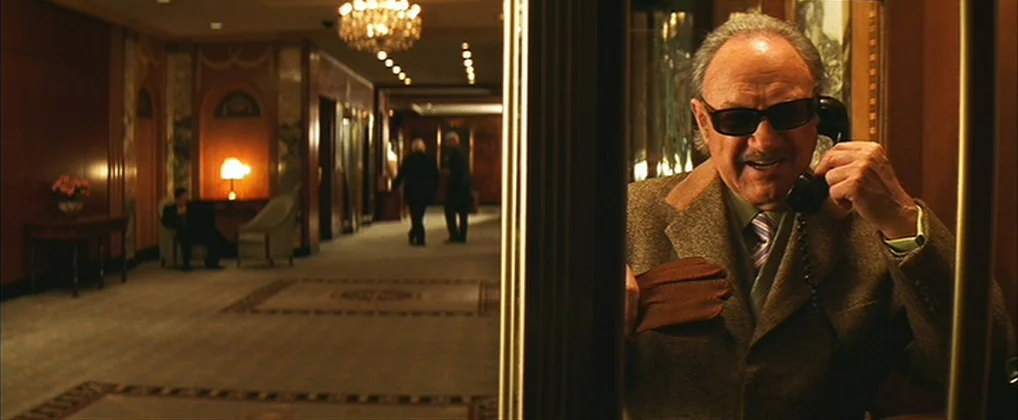 The Royal Tenenbaums (2001) movie still: medium — An upscale hotel lobby features polished wood walls, ornate carpeting, and multiple seating areas.…