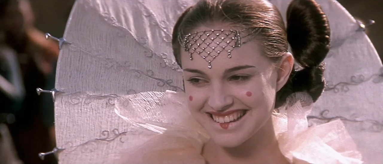 Star Wars: Episode I – The Phantom Menace (1999) movie still: closeup — A ornate fantasy setting features a woman in elaborate white makeup and…