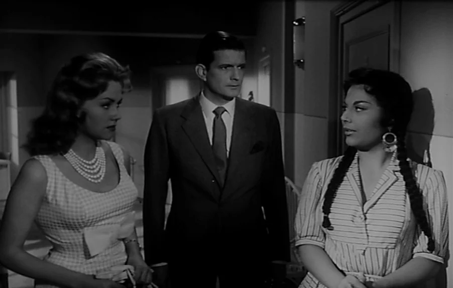 Caltiki, The Immortal Monster (1959) movie still: medium — An interior hallway features three people standing together in a formal arrangement. The…