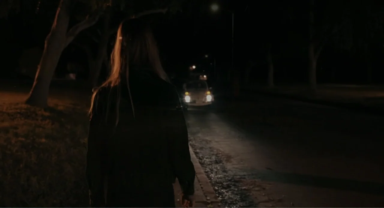 Ted Bundy: American Boogeyman (2021) movie still: medium — A dark residential street at night is illuminated by the bright headlights of a car. A…