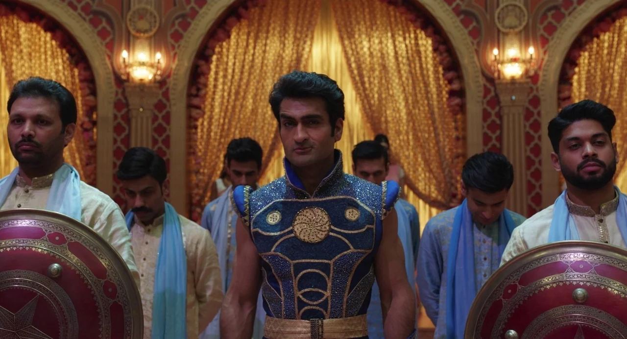 Eternals (2021) movie still: medium — A grand hall featuring arched doorways draped with ornate gold curtains and intricate walls. A man in an…