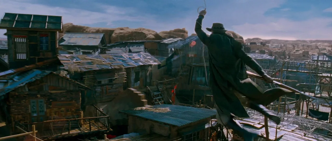 The Good The Bad The Weird (2008) movie still: wide — A dense collection of makeshift wooden and corrugated tin buildings fills a desert canyon. A…