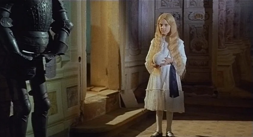 Kill, Baby Kill (1966) movie still: fullbody — An interior hallway features ornately carved wood walls and a dark suit of armor. A young girl stands…