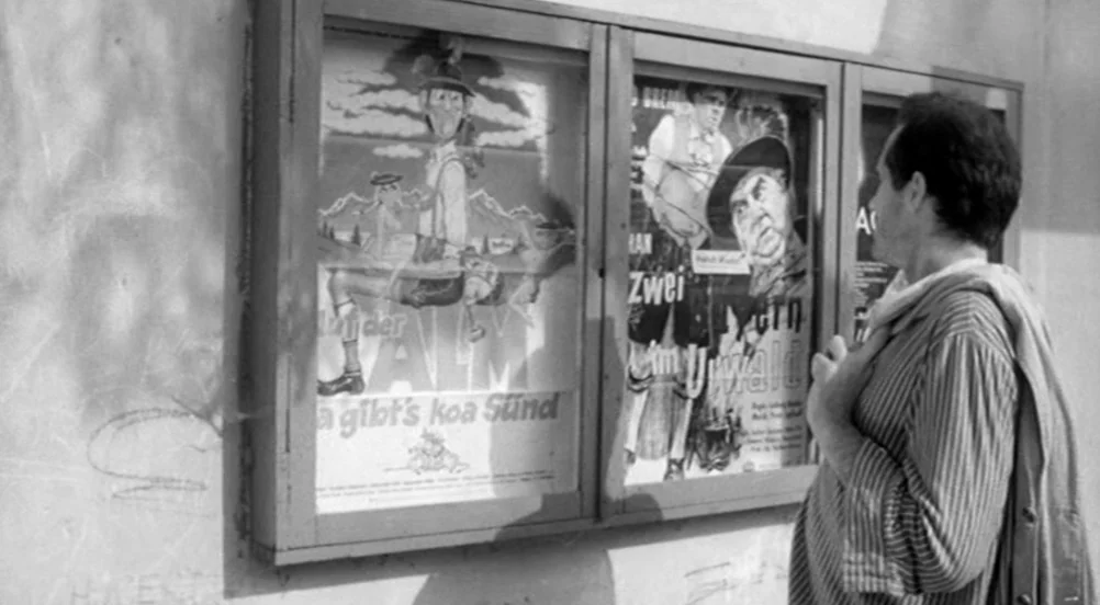 Kings of the Road (Im Lauf der Zeit) (1976) movie still: medium — An outdoor concrete wall features a wooden display case housing several vintage…