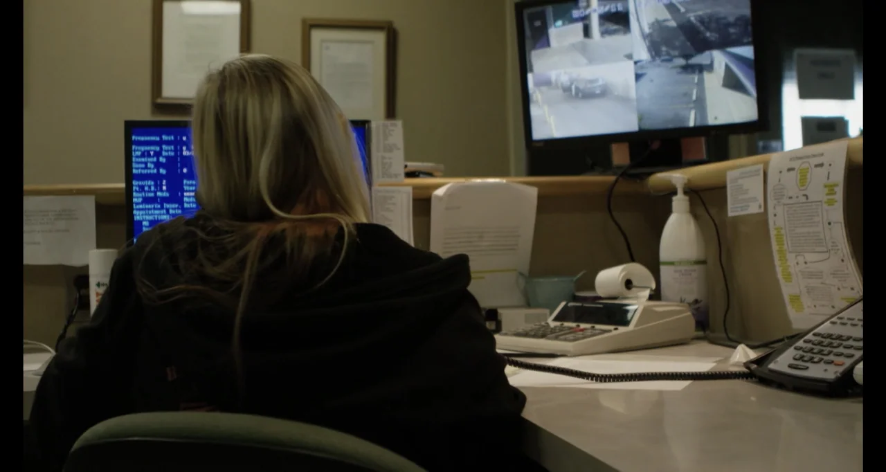Abortion: Stories Women Tell (2016) movie still: medium — A cluttered administrative desk contains multiple computer monitors displaying patient…