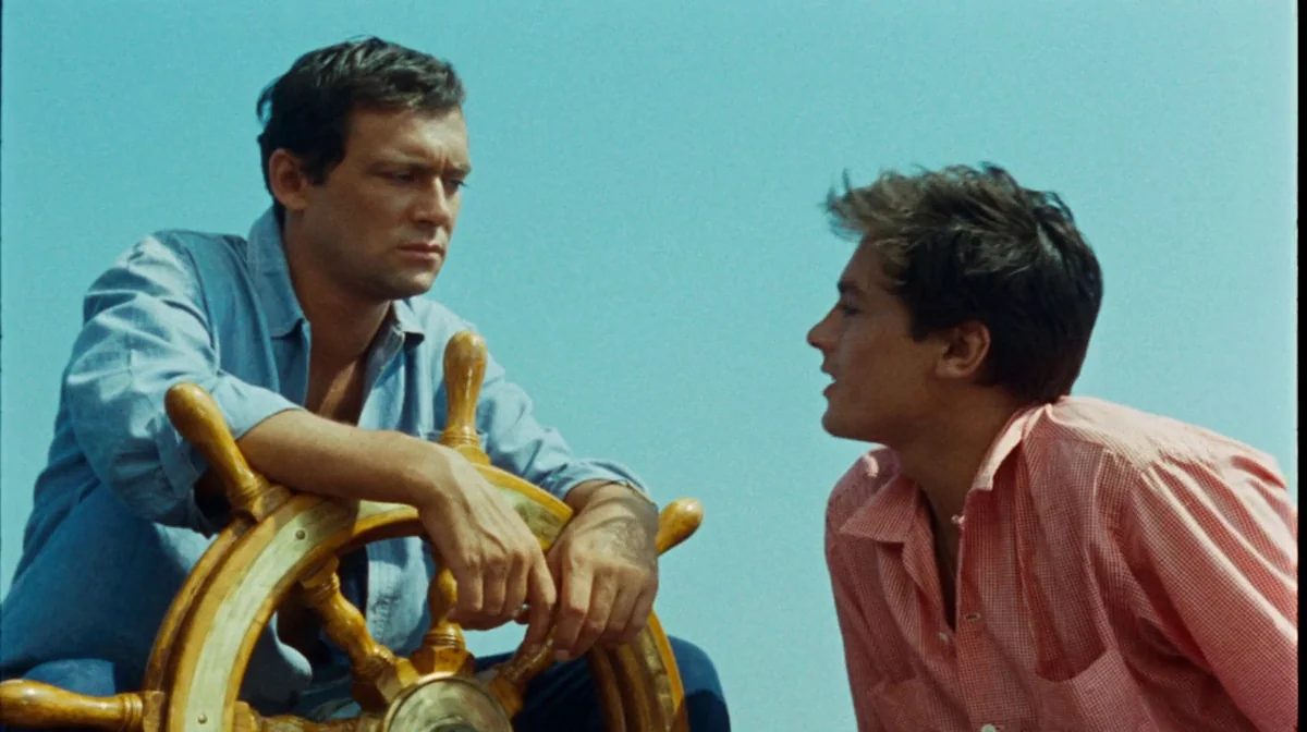 Purple Noon (Plein Soleil) (1960) movie still: medium — The deck of a sailing vessel features a prominent wooden ship's wheel. Two men interact…