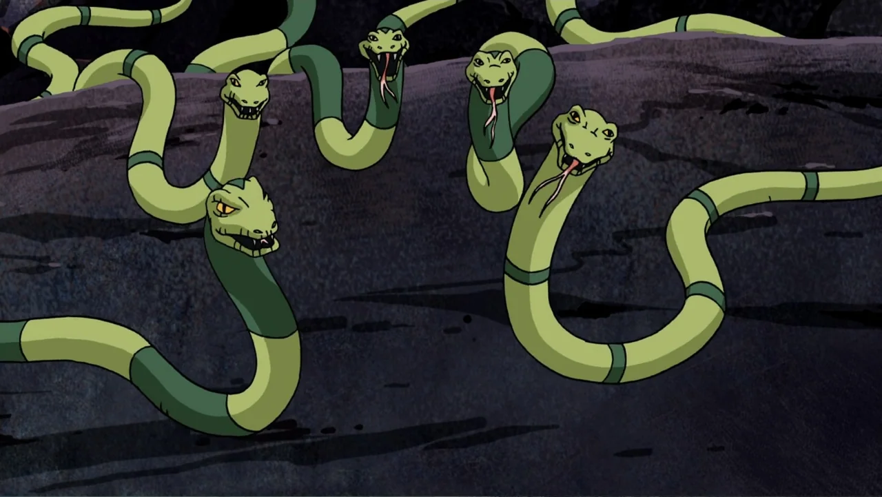 Aloha Scooby-Doo! (2005) movie still: medium — A dark rocky landscape hosts multiple animated green snakes with open mouths. The snakes slither…