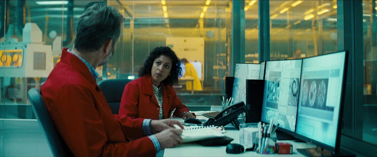 No Time To Die (2021) movie still: medium — A sterile laboratory environment features glass partitions and multiple monitors showing scientific…