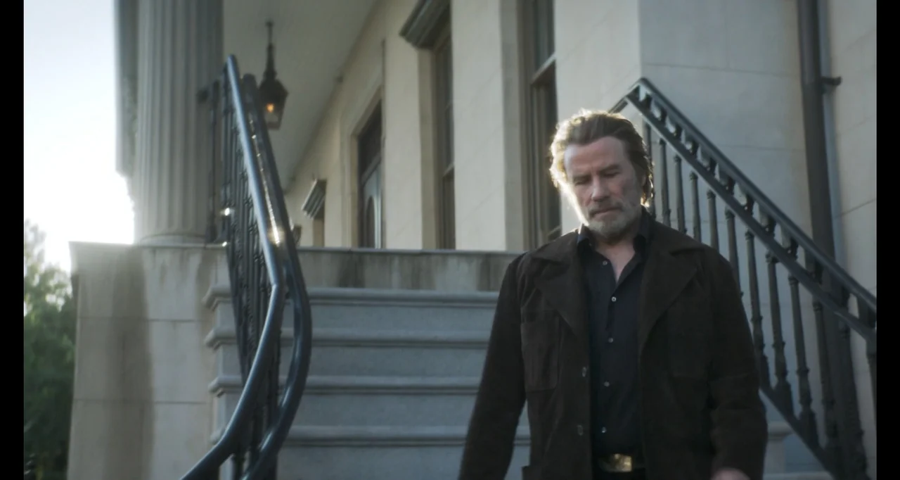 The Poison Rose (2019) movie still: medium — A stone staircase leads up to a pale building with classic architectural columns. An older man in a…