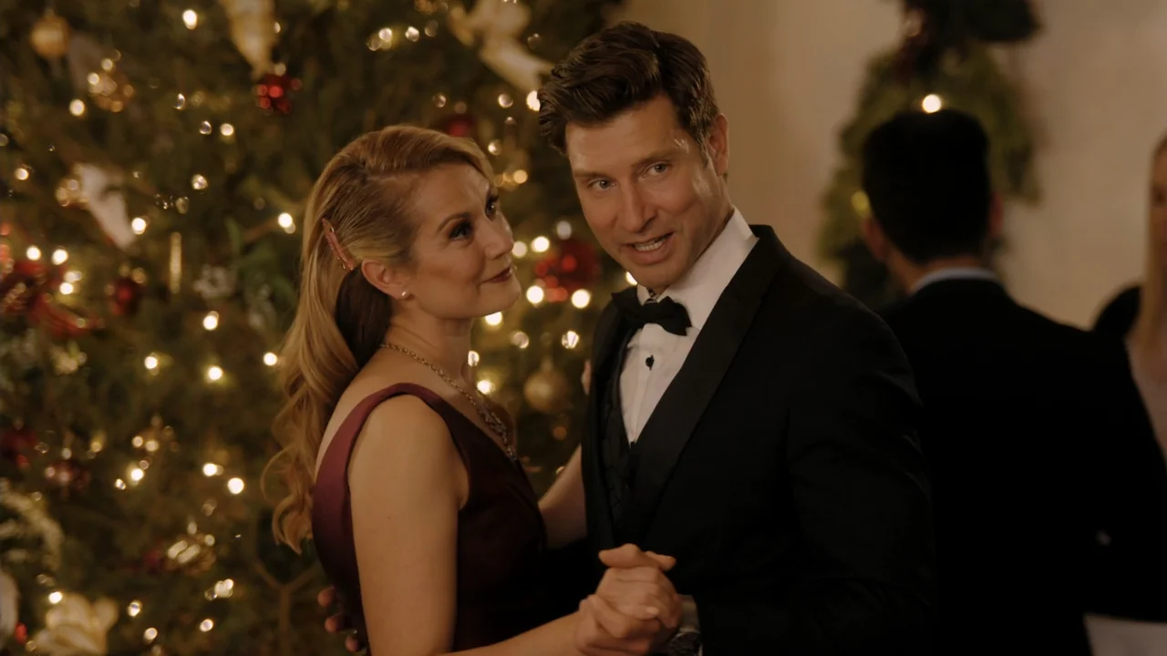 Christmas in Washington (2003) movie still: medium — A decorated room features a large Christmas tree with lit bulbs in the background. A man in a…
