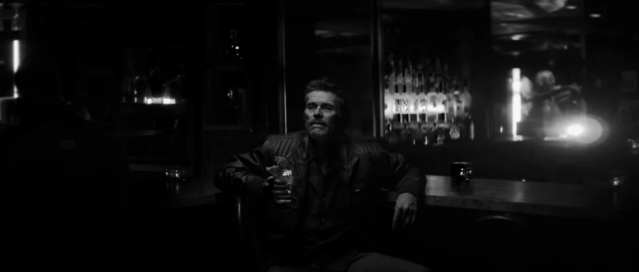 Dog Eat Dog (2016) movie still: medium — A dimly lit counter area features dark surfaces and illuminated bottles in the background. An elderly man…