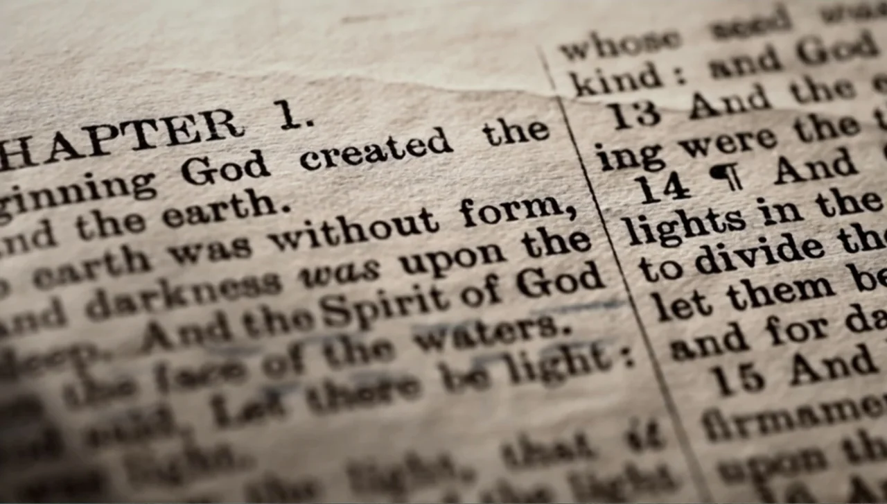Islands of Creation (2015) movie still: closeup — An open book page features weathered paper with dense black printed text. The focus settles on the…