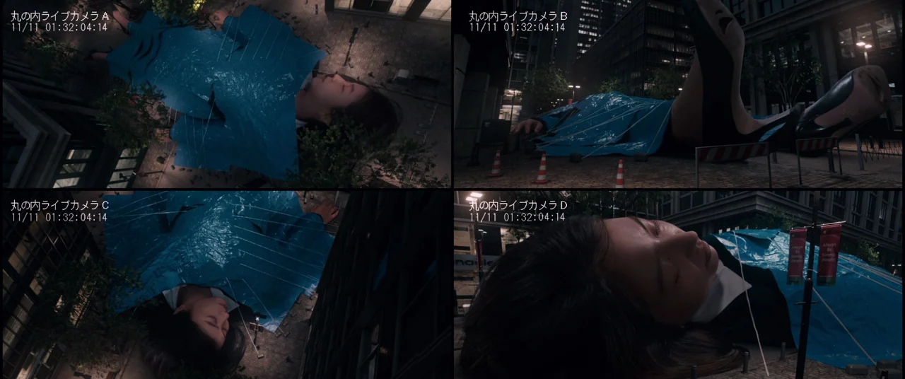 Shin Ultraman (2022) movie still: wide — A giant woman lies on a city street at night covered in blue plastic. Her body dwarfs the surrounding…