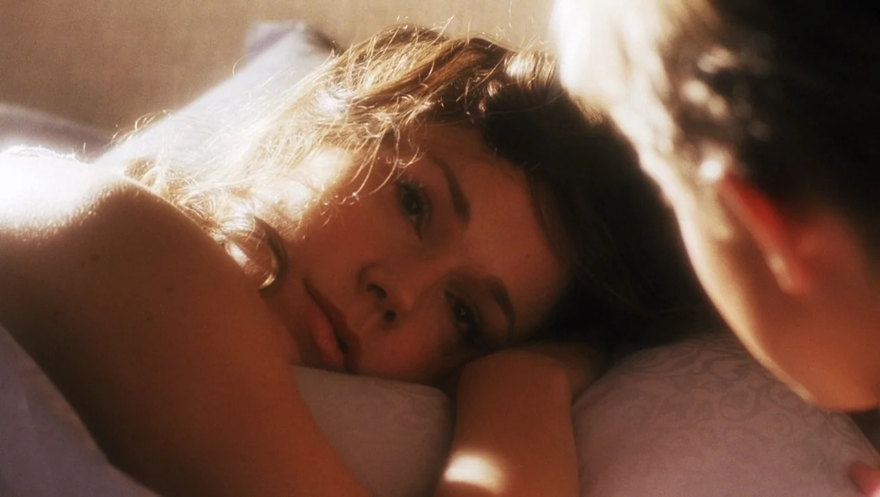 A.I. Artificial Intelligence (2001) movie still: closeup — A person lies on a soft pillow in a brightly lit room. A woman looks toward an unseen…
