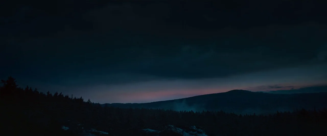 All Quiet on the Western Front (2022) movie still: establishing — A vast mountain range stretches across the horizon during the transition into…
