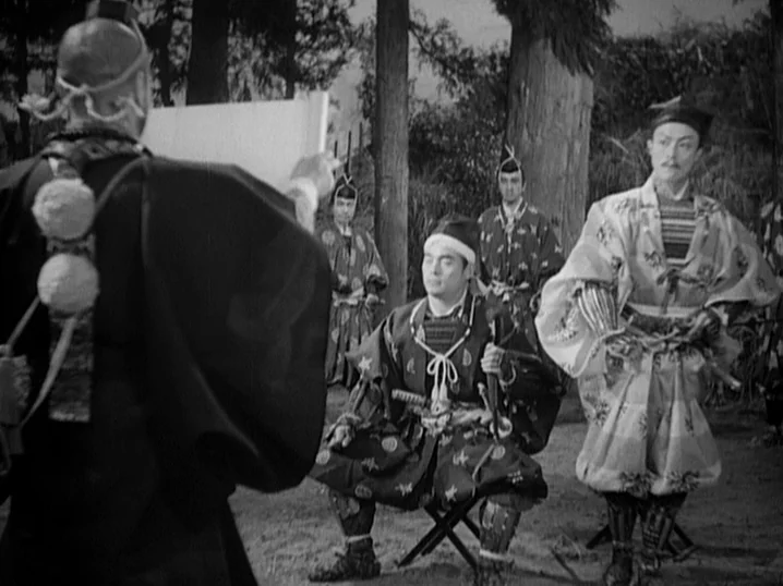 The Men Who Tread on the Tigers Tail (1945) movie still: medium — A group of Japanese men in traditional historical attire stand in a wooded area.…