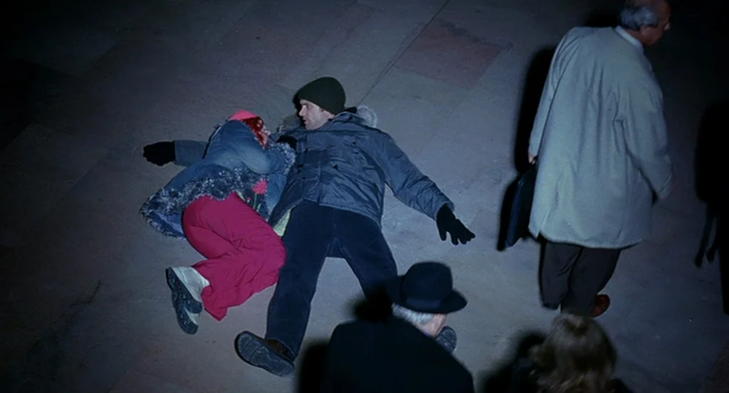 Eternal Sunshine of the Spotless Mind (2004) movie still: wide — A dark paved public area at night with tiled stones and street lighting. A couple…