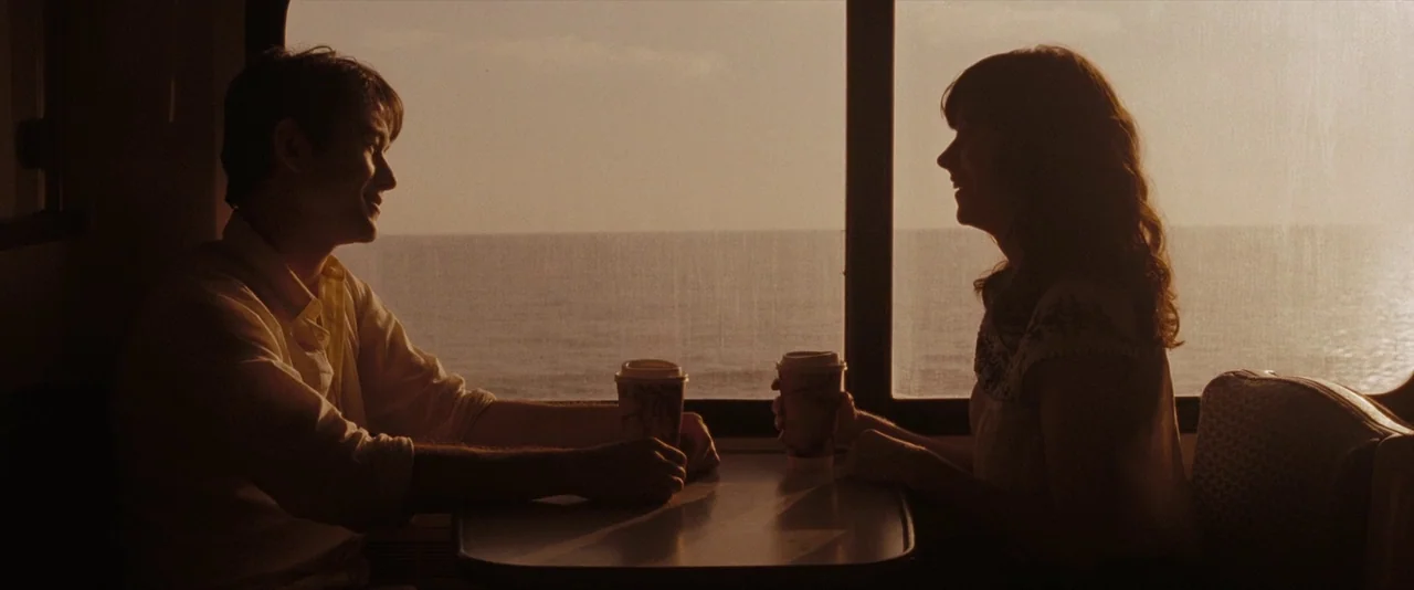 500 Days of Summer (2009) movie still: medium — A passenger train cabin features a small table located beside a large rectangular window. A young…