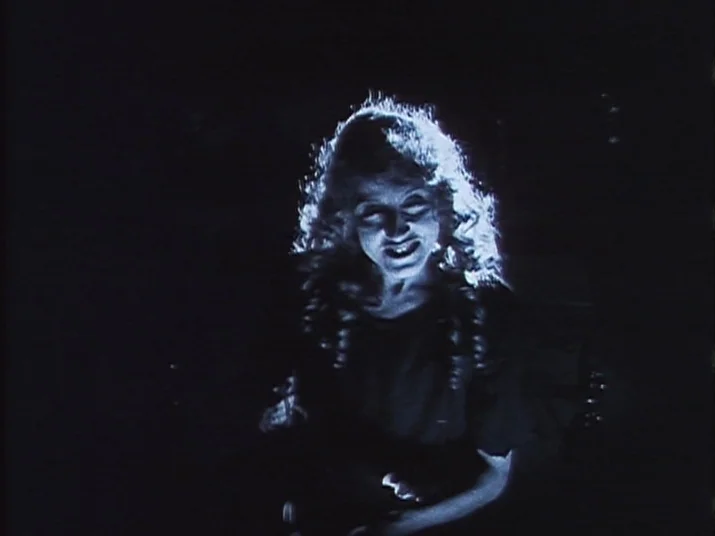Making of: The Wheel (La Roue) (1923) movie still: medium — A dimly lit, pitch-black space features a single woman centered in the frame. The woman…