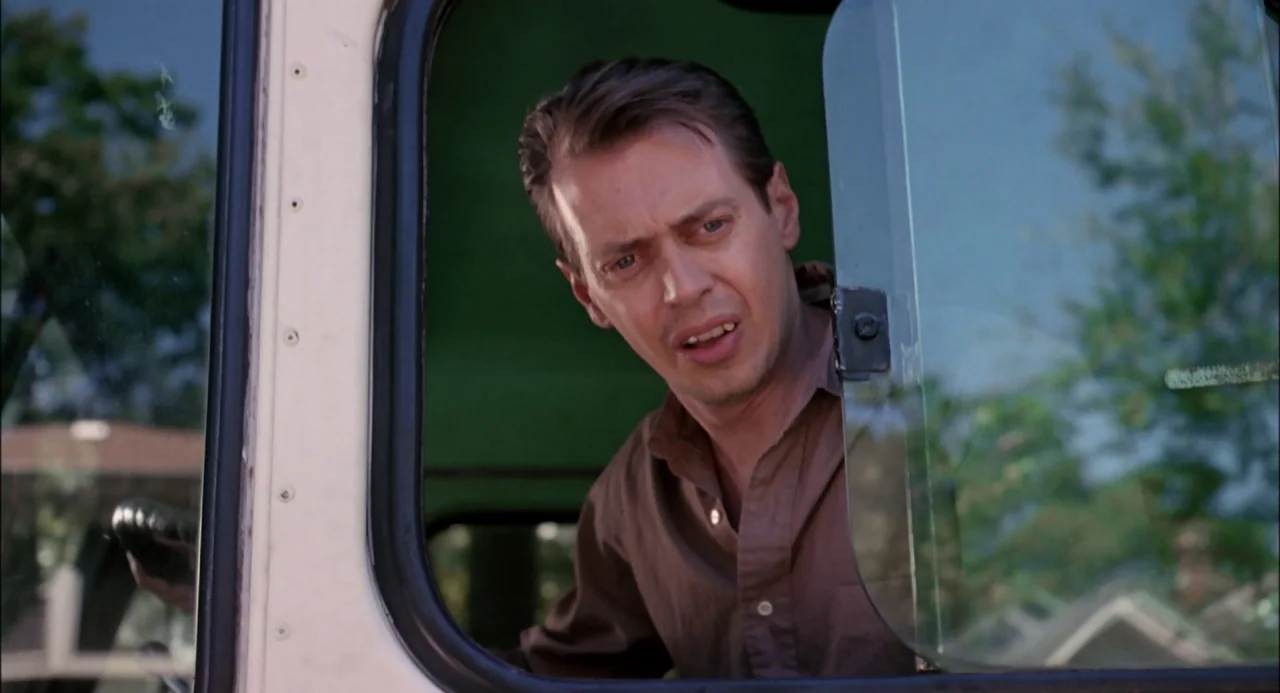 Trees Lounge (1996) movie still: medium — A man sits inside the driver's side of a vehicle with the window down. He leans forward while looking out…