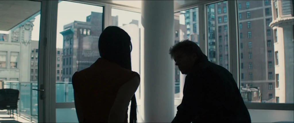 The Girlfriend Experience (2009) movie still: medium — A modern apartment room with floor-to-ceiling windows overlooking urban city buildings. A man…