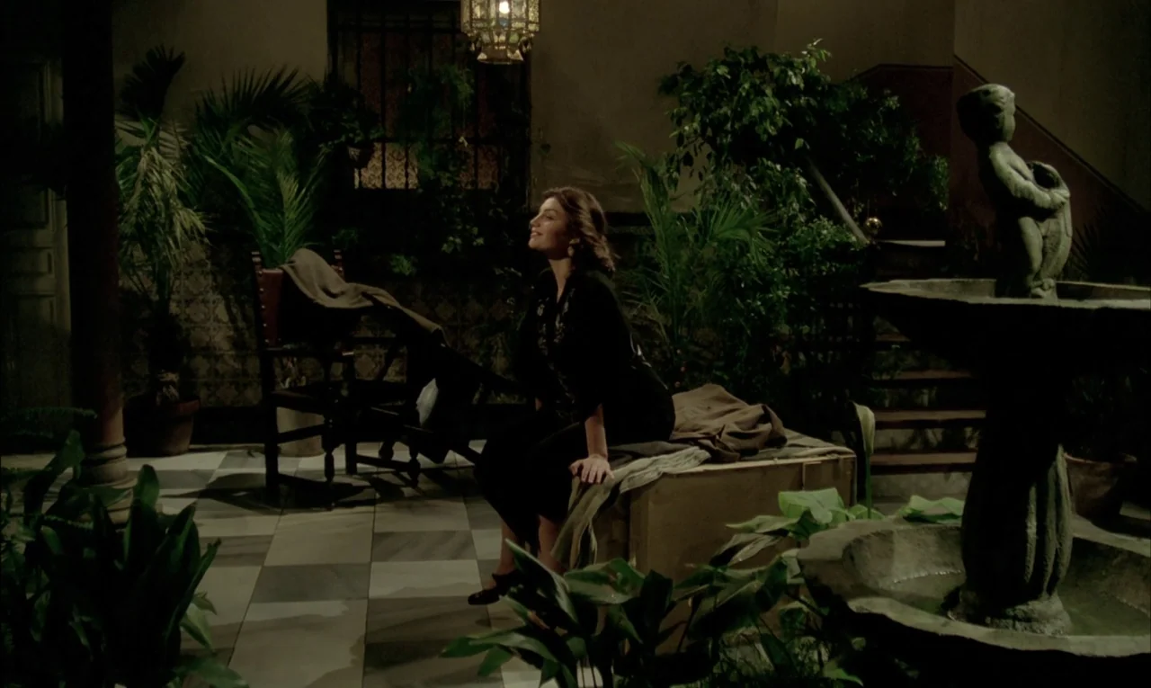 That Obscure Object of Desire (1977) movie still: medium — An interior courtyard with checkered marble flooring features numerous potted plants and…