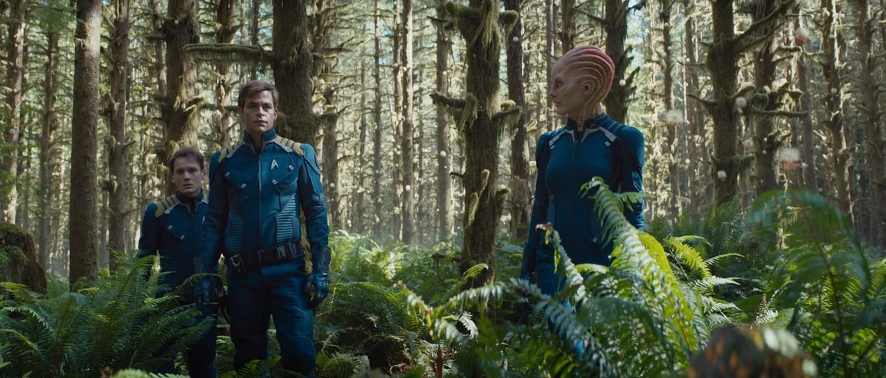 Star Trek Beyond (2016) movie still: fullbody — A dense coniferous woodland with thick moss on trees and lush ground ferns. Three individuals in…