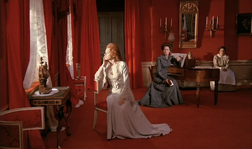 Cries and Whispers (1972) movie still: fullbody — A room with bright red walls and carpet features three women in period attire. One woman sits near…