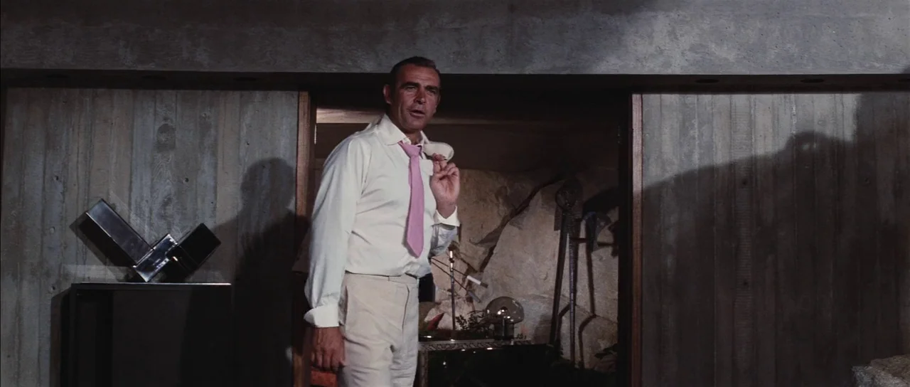 Diamonds Are Forever (1971) movie still: medium — A room with textured, exposed concrete walls and an interior doorway leading to a cavernous area.…