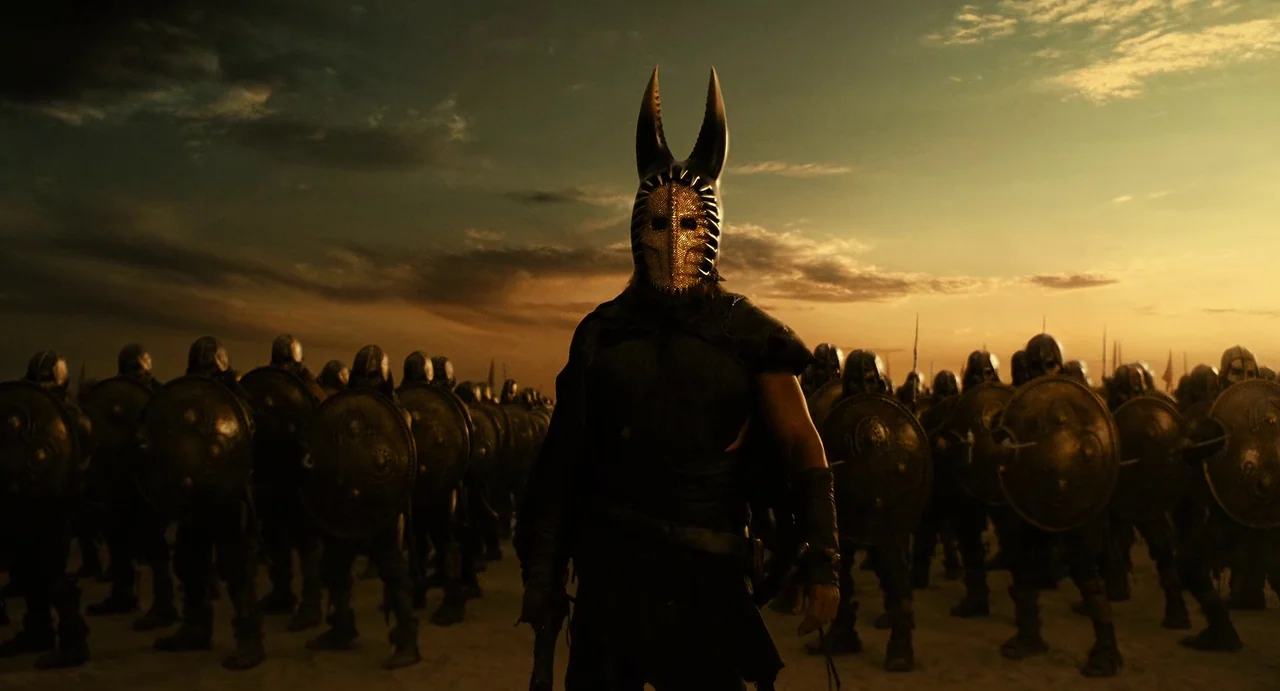 The Immortals (2011) movie still: fullbody — A dense army of soldiers stands in formation on a vast, sandy desert landscape. A central leader…