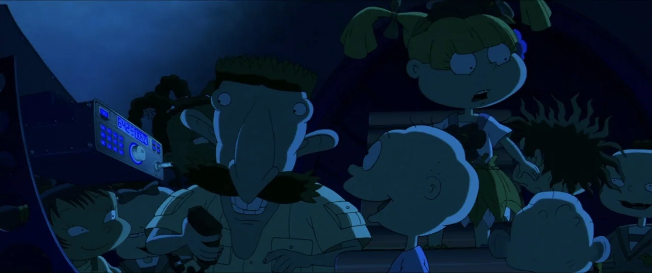 Rugrats Go Wild (2003) movie still: medium — A dark vehicle cabin is illuminated by the glow of a blue frequency radio. Several animated characters…