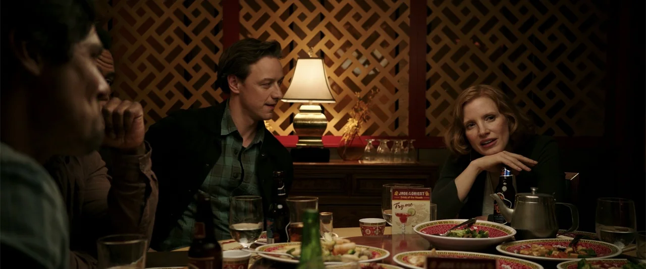 K.G.F: Chapter 2 (2022) movie still: medium — A dimly lit restaurant interior features a wooden lattice screen wall and a table lamp. Two adults sit…