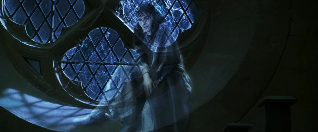 Harry Potter and the Chamber of Secrets (2002) movie still: medium — A dark stone interior features a large, round, leaded glass window at night. A…