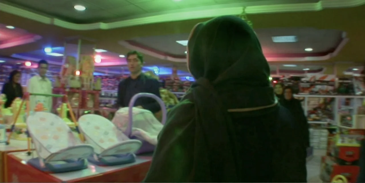 Silencing the Song: An Afghan Fallen Star (2011) movie still: medium — A well-lit commercial retail space features rows of shelves filled with…
