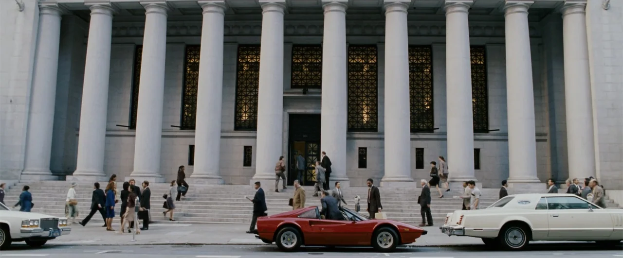 The Pursuit of Happyness (2006) movie still: wide — A classical stone building with large columns stands behind wide steps and sidewalk. Numerous…