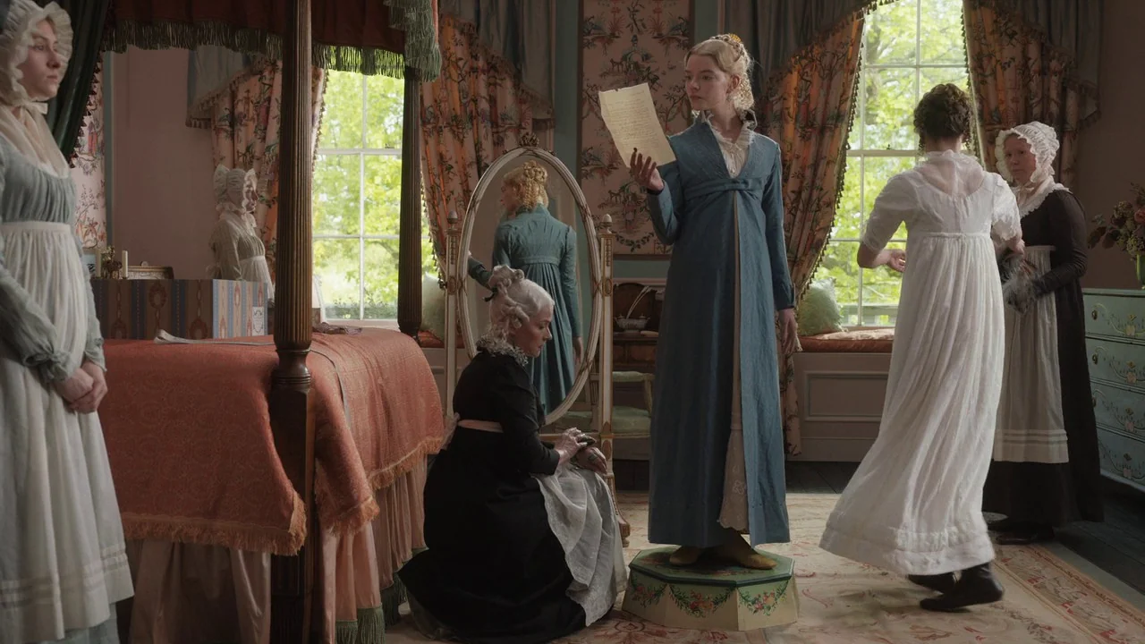 Emma. (2020) movie still: medium — A 19th-century dressing room features a four-poster bed and ornate floral wallpaper. Several women in period…