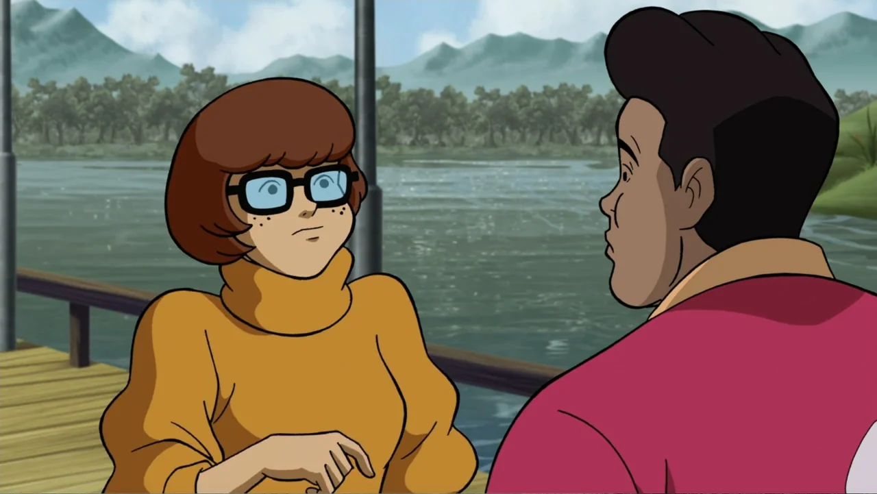Scooby-Doo! Return to Zombie Island (2019) movie still: medium — A wooden pier stretches across a lake with distant green mountains under a cloudy…