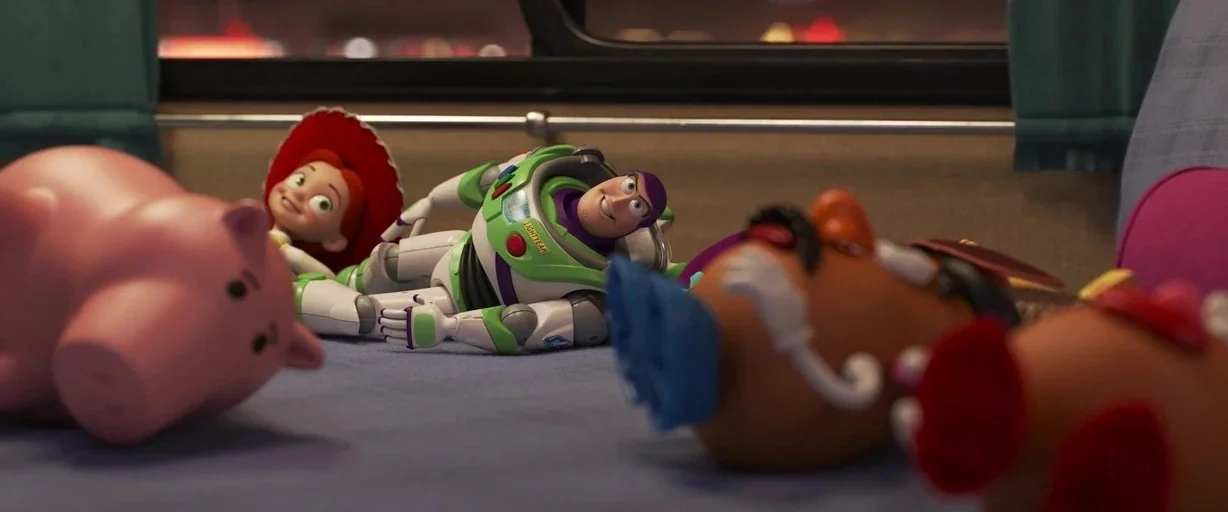 Toy Story 4 (2019) movie still: medium — The interior of a passenger bus with blue fabric upholstery and dark windows. Several toy characters lie…