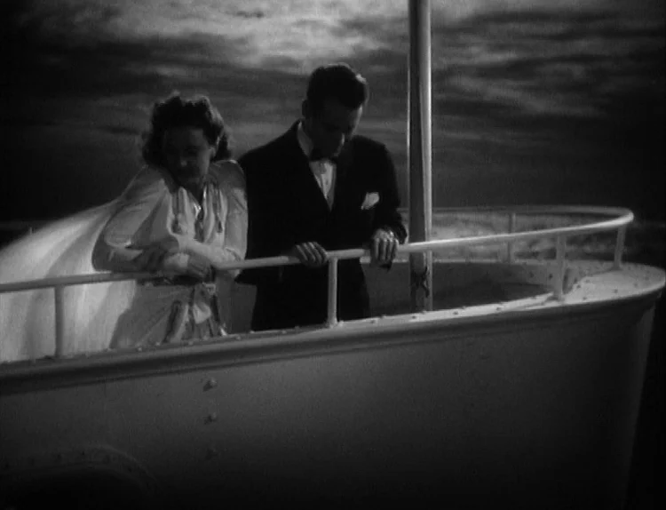 The Lady Eve (1941) movie still: medium — A man and woman in formal attire stand on the deck of a boat. They lean against a railing at night with a…