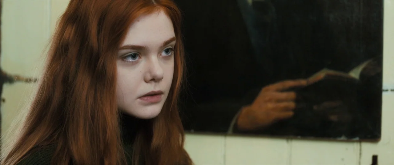 Ginger & Rosa (2012) movie still: closeup — A dimly lit room with pale tiled walls and a dark wall-mounted mirror. A young woman with long…