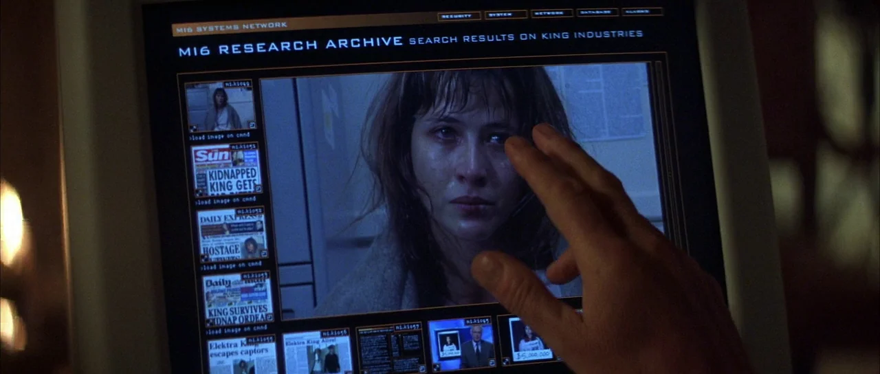 The World is Not Enough (1999) movie still: closeup — An computer monitor displays an MI6 archive search result with news clippings about a…