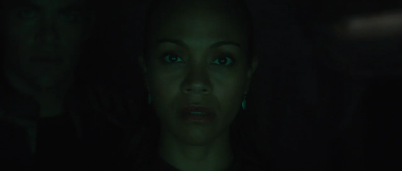 Star Trek Beyond (2016) movie still: closeup — A dark, dimly lit environment features two people positioned close to the camera. The woman is…