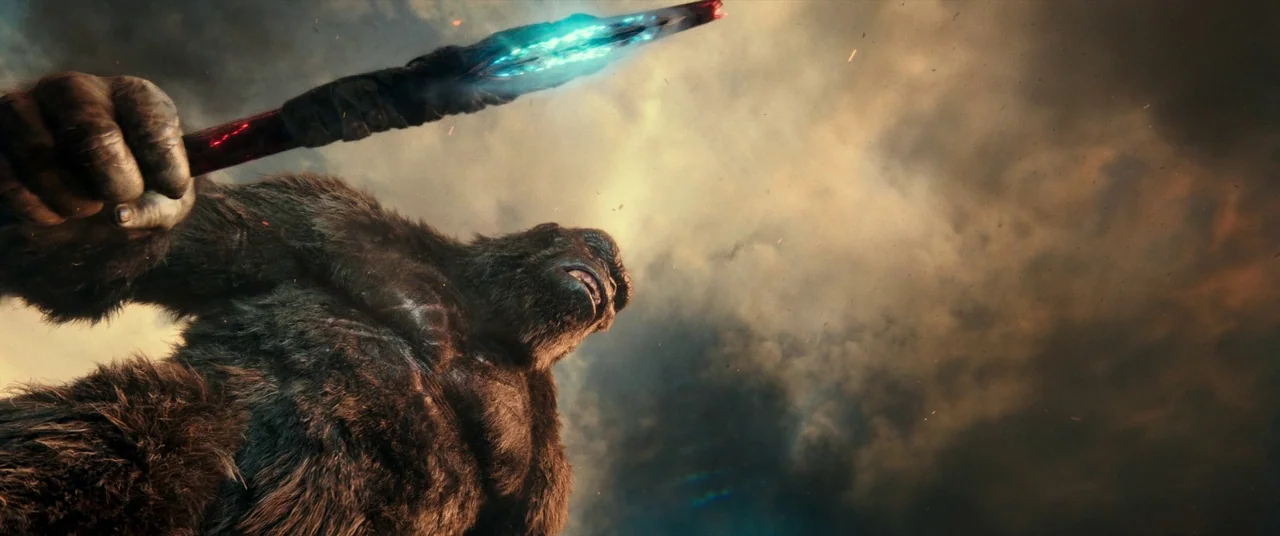 Godzilla Vs. Kong (2021) movie still: fullbody — A gargantuan ape creature stands in a vast, desolate landscape beneath a turbulent, clouded sky.…