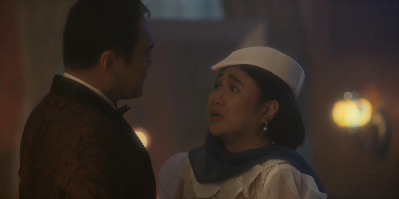 Ten Little Mistresses (2023) movie still: medium — A dimly lit interior space features ornate wall fixtures and soft atmospheric haze. A woman in a…