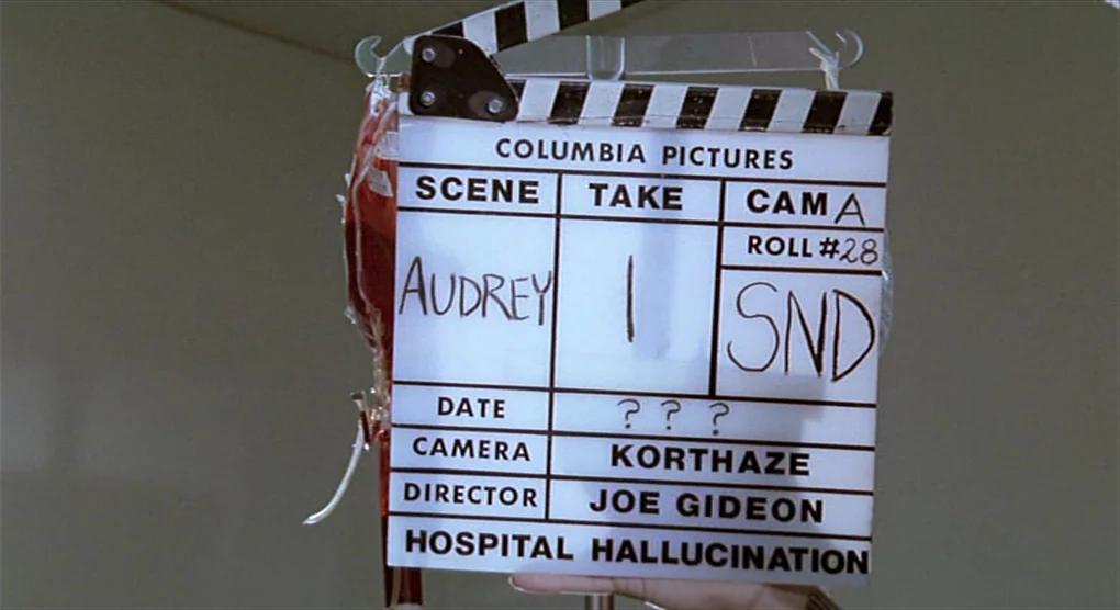 All That Jazz (1979) movie still: closeup — A white plastic film slate displays production information including the film title and scene details.…