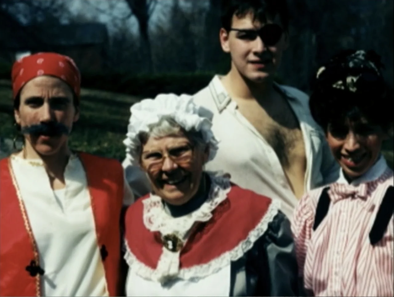 A Rape in a Small Town: The Florence Holway Story (2005) movie still: medium — A group of four people in diverse costumes stand outdoors in bright…