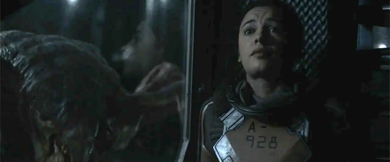 DISTANT (2026) movie still: closeup — A dark, cramped interior with metallic wall textures and a reflective black glass surface. A woman in a…