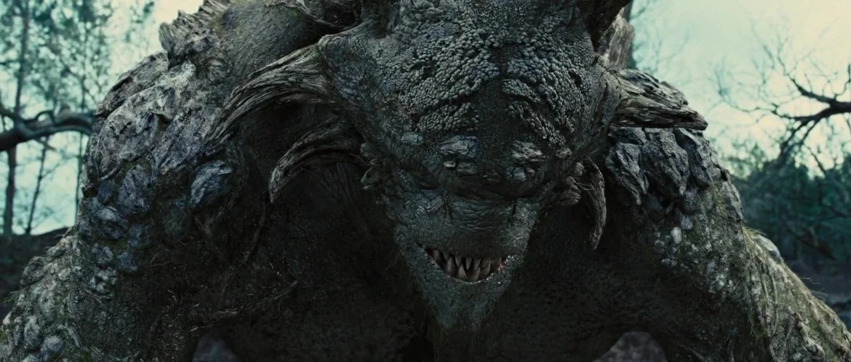 Snow White and The Huntsman (2012) movie still: closeup — A gargantuan tree-like creature stands in a dense, overcast outdoor setting. The monster…