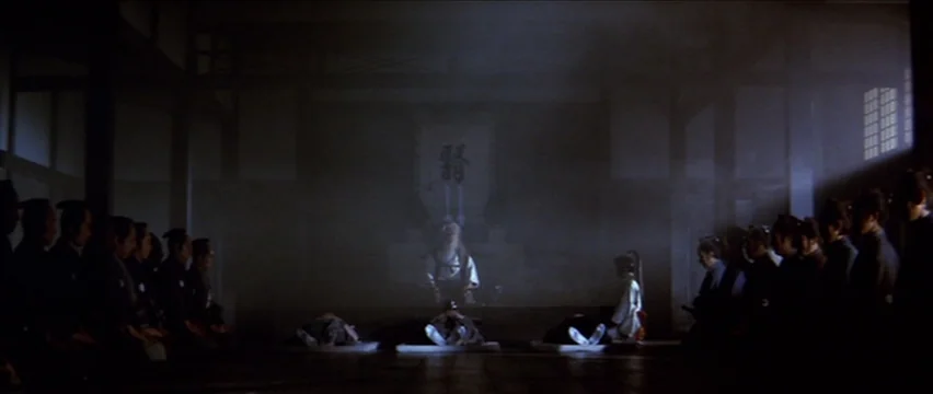 Lone Wolf and Cub: White Heaven in Hell (1974) movie still: wide — A dark, expansive room with traditional wooden architecture and a thick,…
